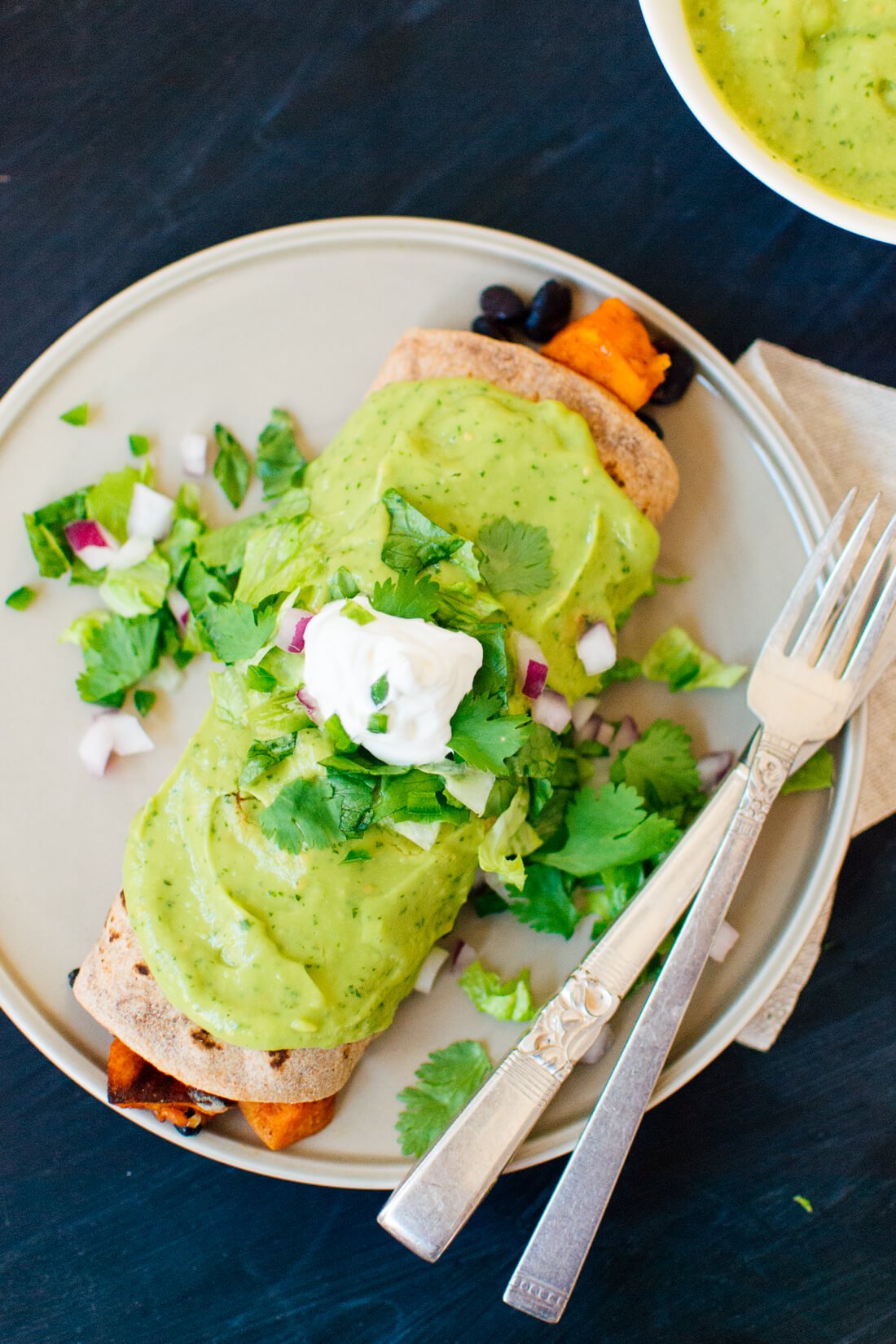 Sweet potato burrito with avocado sauce and sour cream