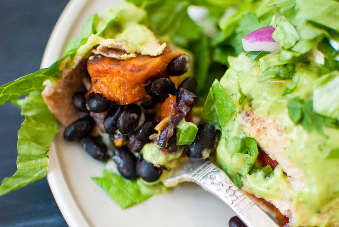 bite of burrito with avocado sauce