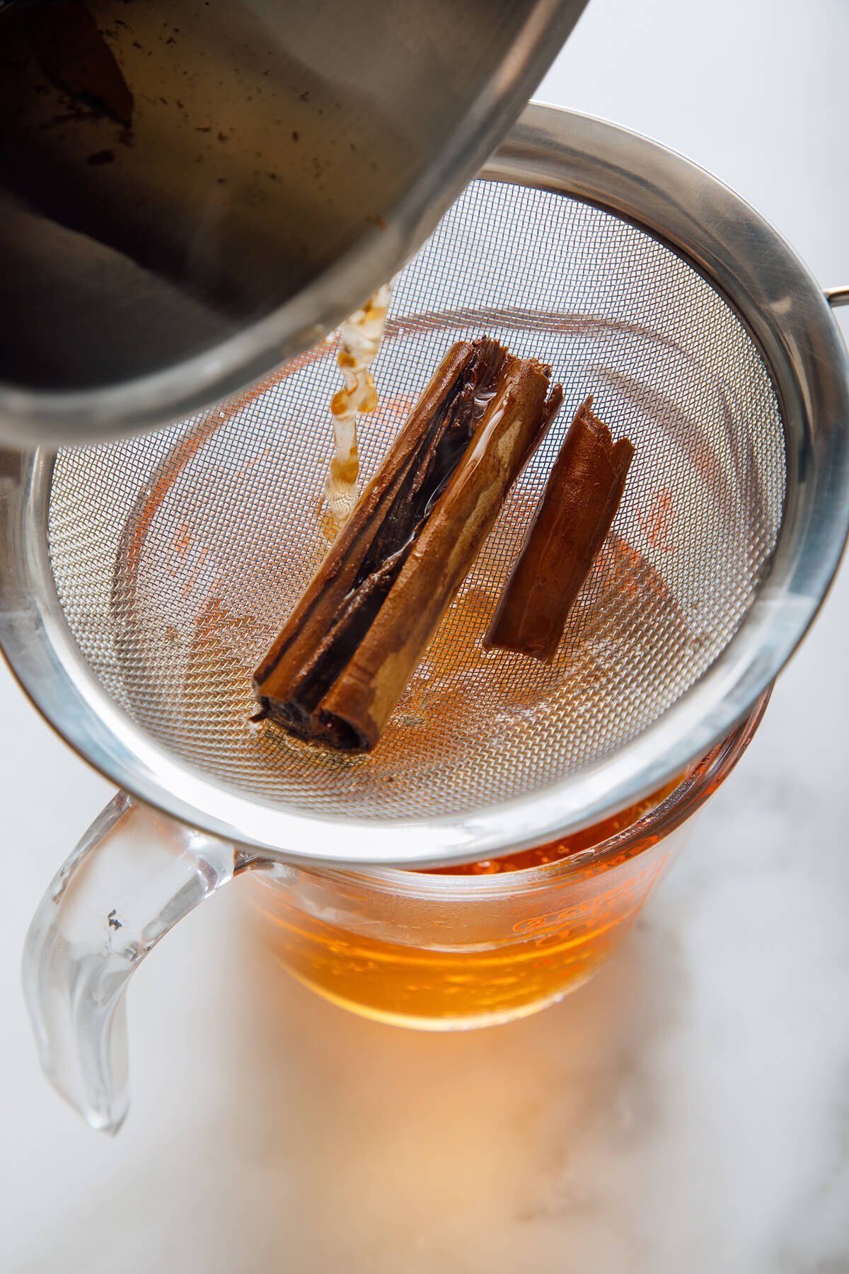 straining cinnamon from tea